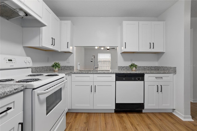 kitchen featuring white appliances, range hood, white cabinets, and a sink