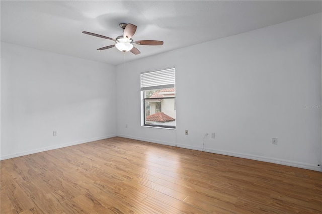 empty room with baseboards, ceiling fan, and light wood finished floors