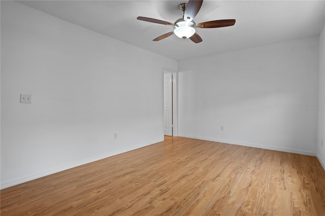 spare room featuring light wood-style flooring, baseboards, and a ceiling fan