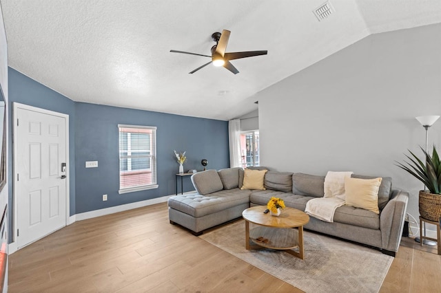 living room featuring light hardwood / wood-style floors, a wealth of natural light, and vaulted ceiling