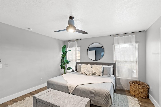 bedroom featuring ceiling fan, a textured ceiling, and hardwood / wood-style flooring