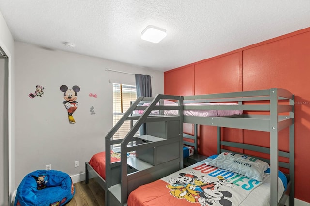 bedroom with hardwood / wood-style floors and a textured ceiling