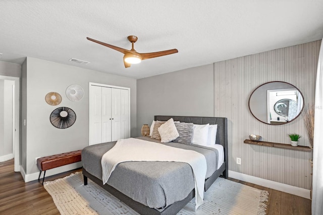 bedroom featuring ceiling fan, a textured ceiling, a closet, and dark hardwood / wood-style flooring