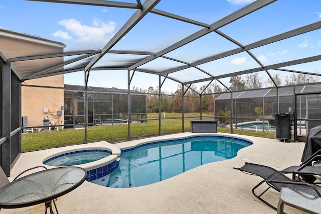 view of pool with an in ground hot tub, a lanai, a yard, and a patio