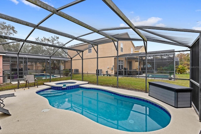 view of swimming pool featuring an in ground hot tub, glass enclosure, a lawn, and a patio