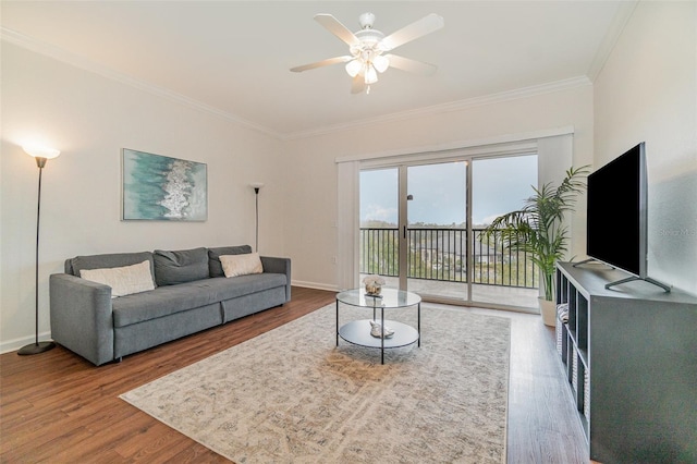 living room featuring hardwood / wood-style flooring, ceiling fan, and crown molding