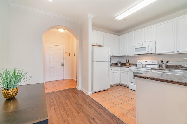 kitchen featuring white appliances, light tile patterned floors, sink, and white cabinets