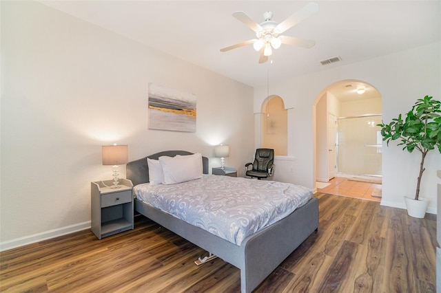 bedroom with ceiling fan, wood-type flooring, and ensuite bath