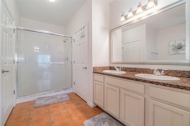 bathroom with tile patterned floors, a shower with door, and vanity