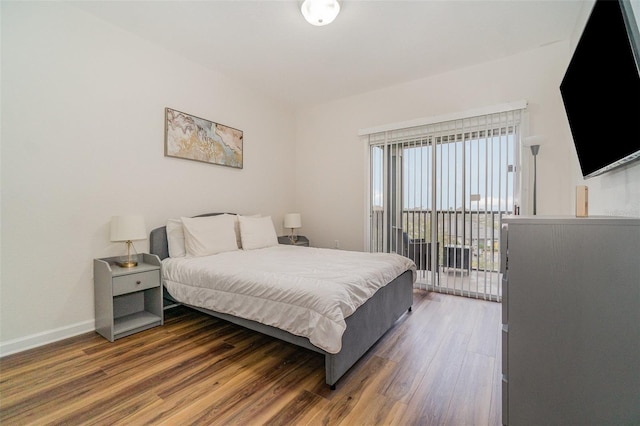 bedroom with dark hardwood / wood-style floors and access to outside