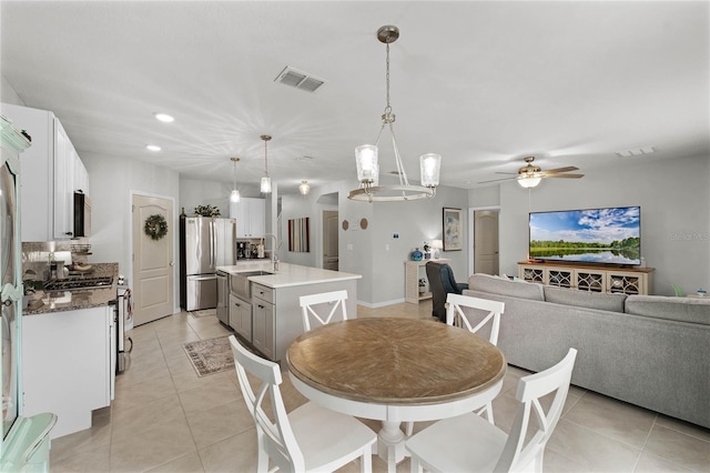 tiled dining room featuring ceiling fan and sink