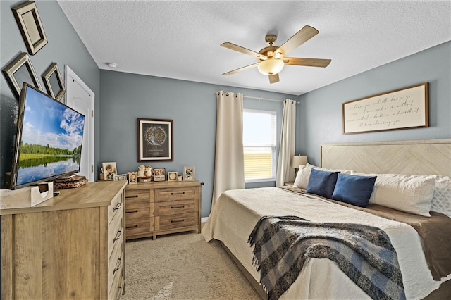 carpeted bedroom featuring a textured ceiling and ceiling fan