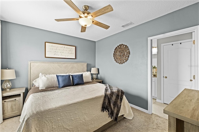 carpeted bedroom featuring ceiling fan and a textured ceiling