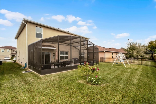 rear view of property with a playground and a yard