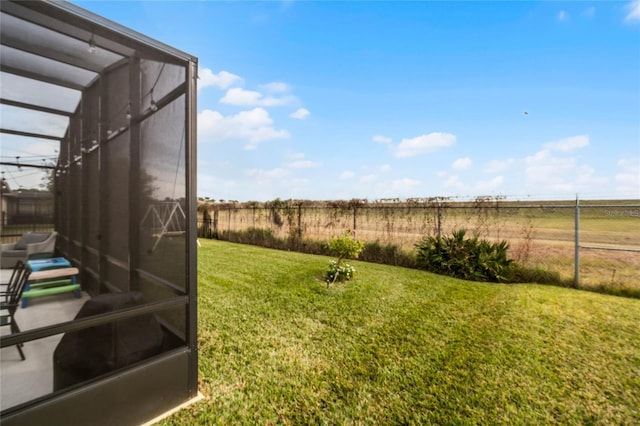 view of yard featuring glass enclosure and a rural view