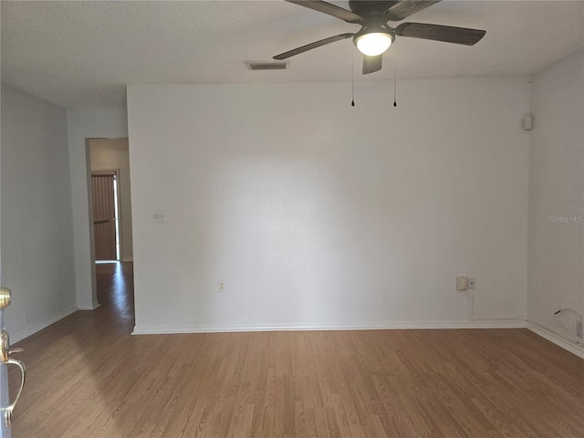 unfurnished room with a textured ceiling, ceiling fan, and hardwood / wood-style flooring