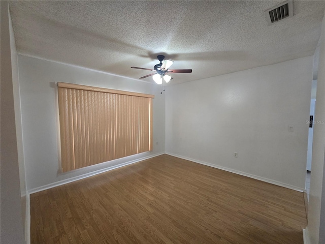 spare room featuring ceiling fan, dark hardwood / wood-style flooring, and a textured ceiling