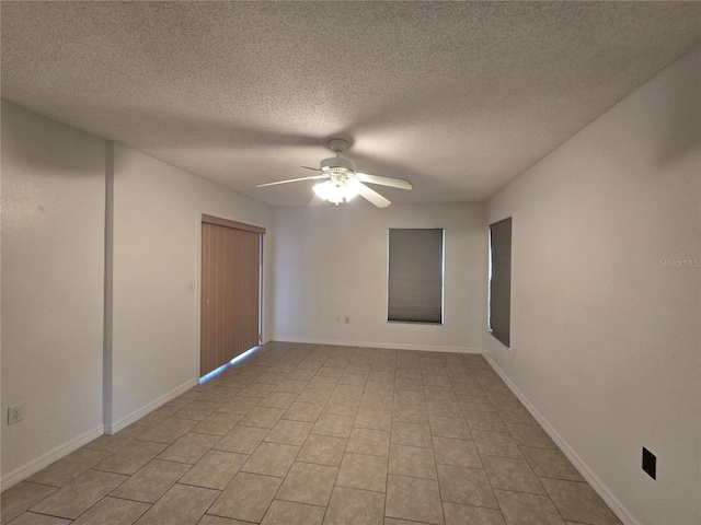 empty room with ceiling fan and a textured ceiling