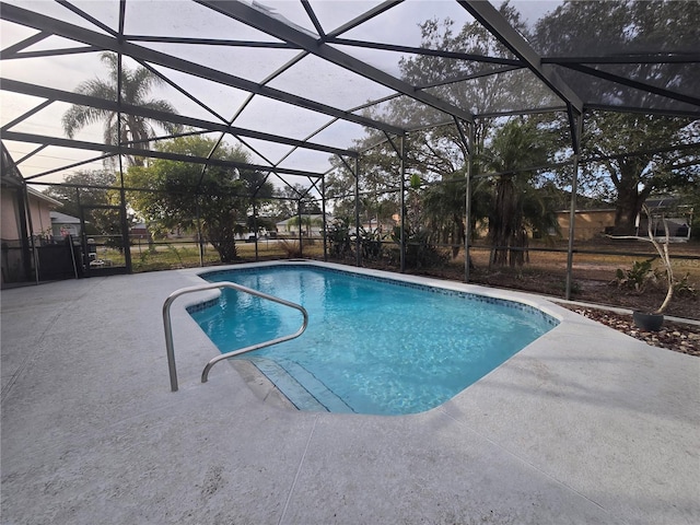 view of swimming pool featuring glass enclosure and a patio area