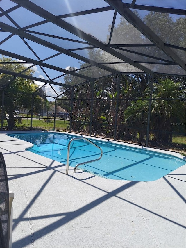 view of swimming pool featuring a lanai and a patio area