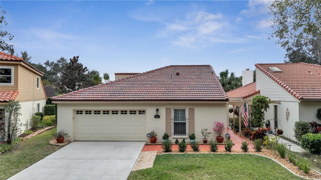 mediterranean / spanish-style house featuring a front yard and a garage