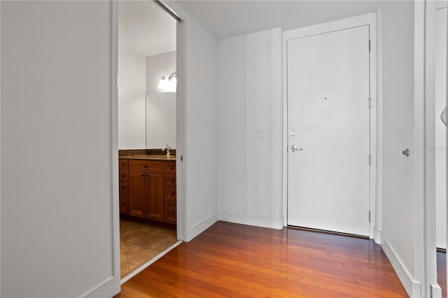 hallway with sink and hardwood / wood-style floors