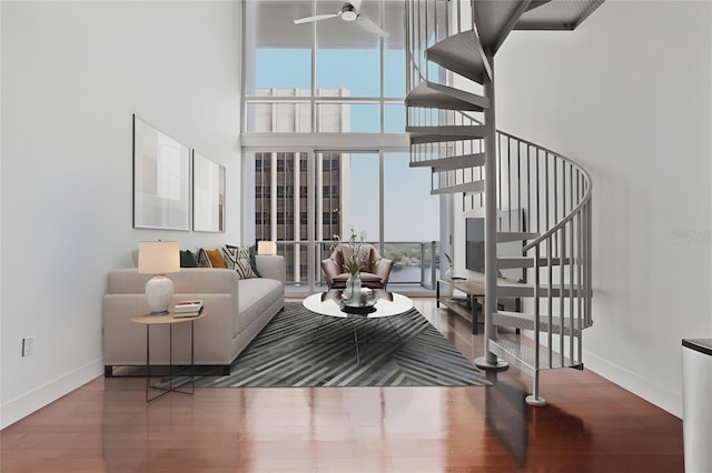 living room with ceiling fan, a high ceiling, and hardwood / wood-style floors