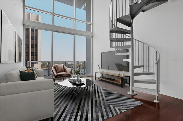 living room featuring a towering ceiling and hardwood / wood-style flooring