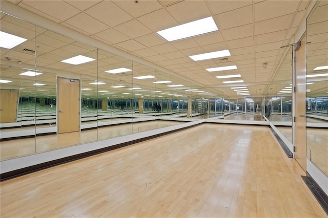 interior space with a paneled ceiling and wood-type flooring