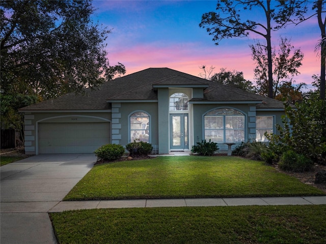 view of front of home with a lawn and a garage