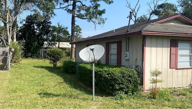 view of side of home with a yard