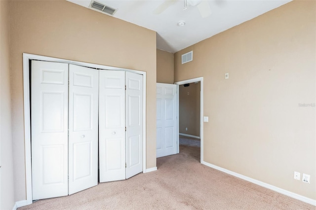 unfurnished bedroom featuring ceiling fan, a closet, and light colored carpet