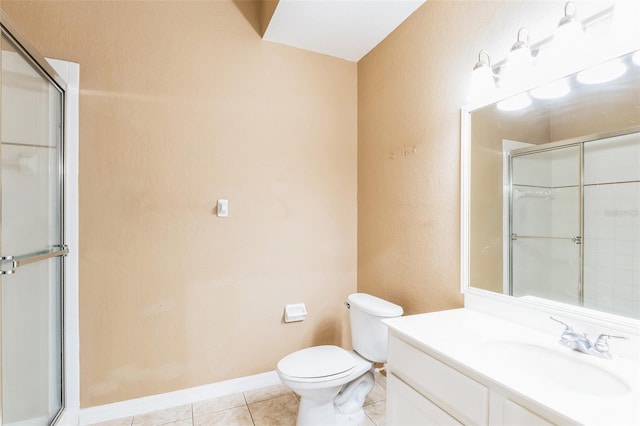 bathroom featuring tile patterned floors, toilet, vanity, and an enclosed shower