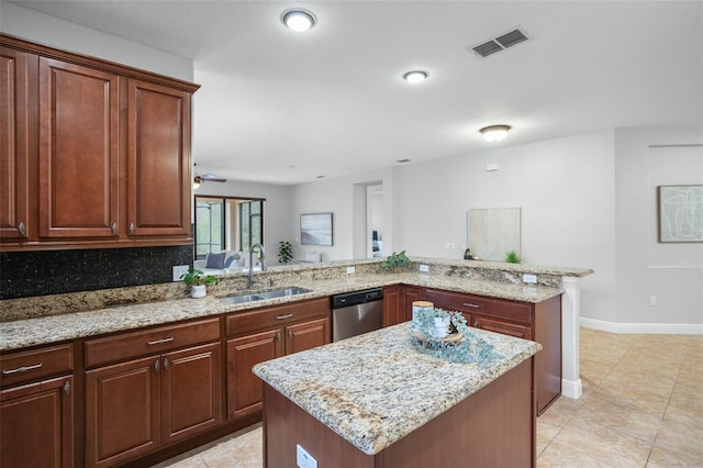 kitchen featuring kitchen peninsula, stainless steel dishwasher, sink, a center island, and decorative backsplash