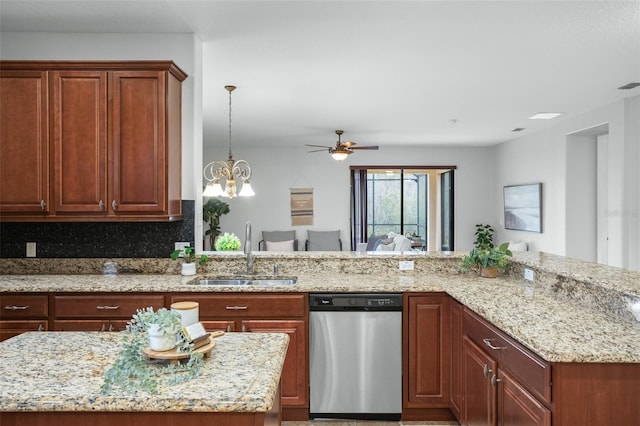 kitchen with light stone countertops, pendant lighting, tasteful backsplash, sink, and stainless steel dishwasher