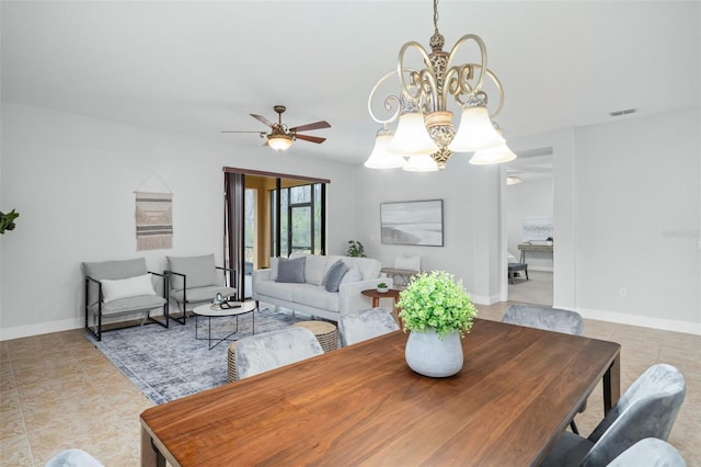 tiled dining room featuring ceiling fan with notable chandelier