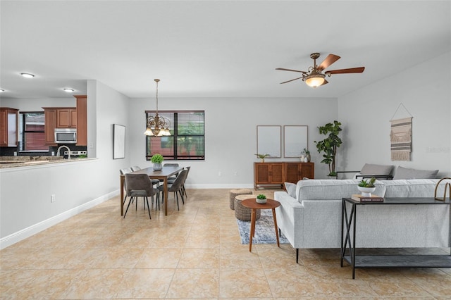 living room with ceiling fan with notable chandelier and light tile patterned floors