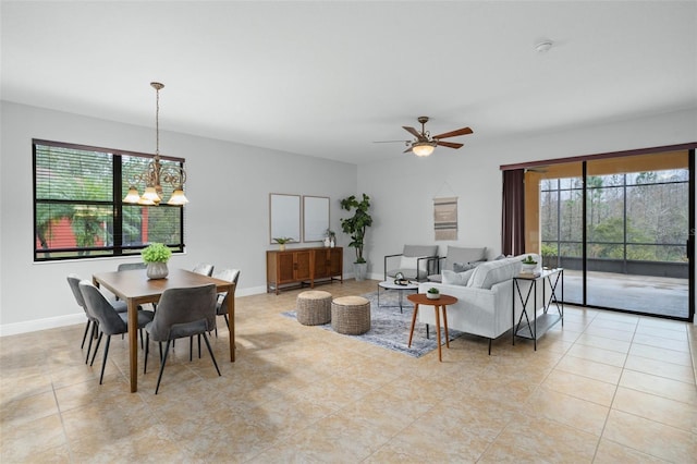 living room featuring ceiling fan with notable chandelier and light tile patterned floors