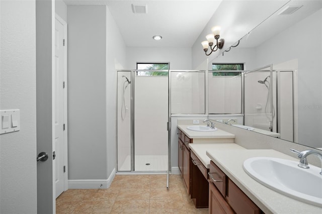 bathroom with tile patterned flooring, an enclosed shower, a wealth of natural light, and vanity