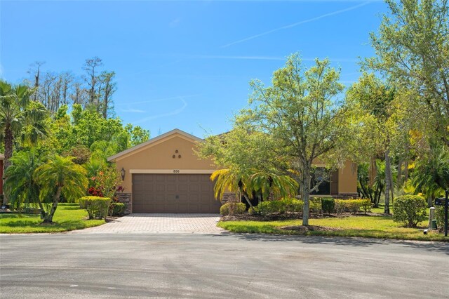 800 Ebb Tide Ln, Kissimmee, FL 34759 - view of front facade featuring stone siding, stucco siding, driveway, and a garage