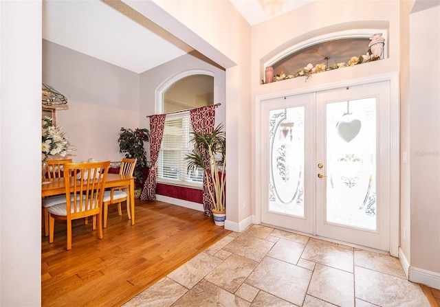 foyer featuring light wood-type flooring and french doors