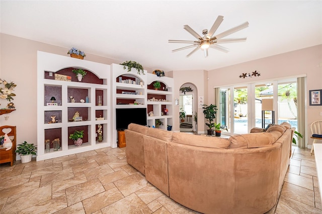 living room with ceiling fan, built in features, and french doors