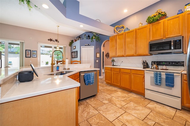 kitchen featuring decorative light fixtures, stainless steel appliances, an inviting chandelier, sink, and a kitchen island with sink