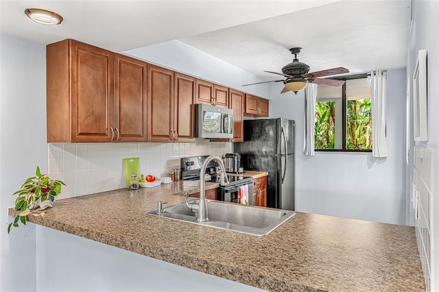 kitchen with ceiling fan, backsplash, appliances with stainless steel finishes, and kitchen peninsula