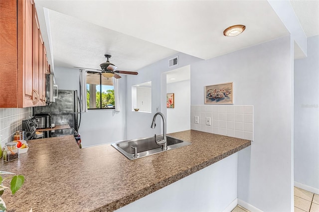 kitchen with tasteful backsplash, ceiling fan, sink, light tile patterned flooring, and range