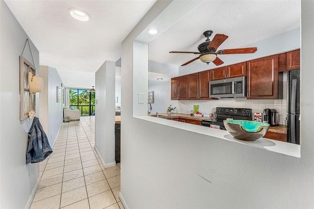 kitchen with tasteful backsplash, ceiling fan, kitchen peninsula, appliances with stainless steel finishes, and light tile patterned floors