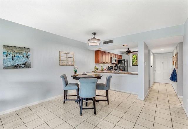 dining room with ceiling fan and light tile patterned flooring