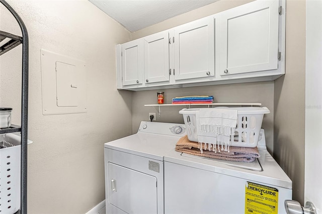 laundry area with cabinets, a textured ceiling, electric panel, and washing machine and dryer