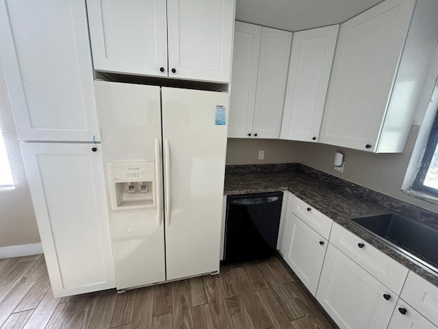 kitchen with white cabinets, dishwasher, white refrigerator with ice dispenser, dark stone countertops, and sink