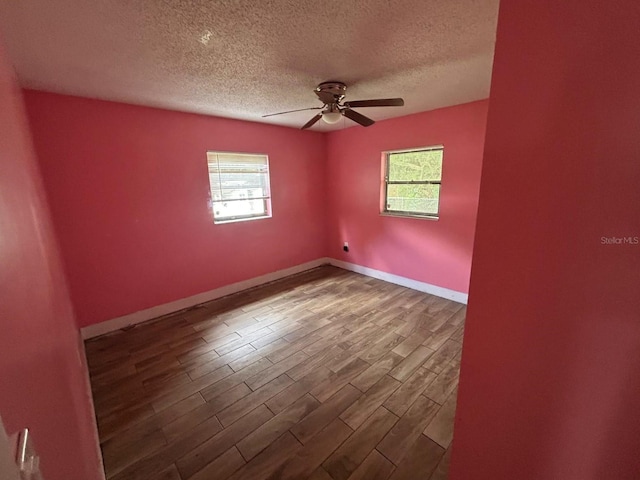 empty room featuring ceiling fan, hardwood / wood-style floors, and a textured ceiling